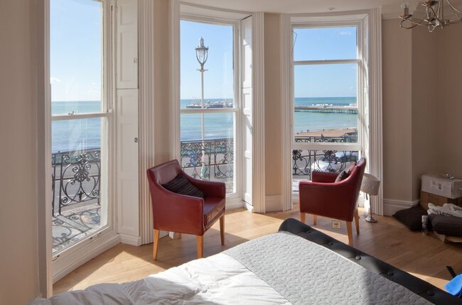 A Room With a View, an open window with wooden shutters looking out to sea. 